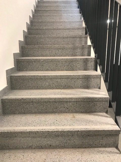 Betonwerkstein & Holztreppe: Betonwerkstein-Winkelstufen auf Stahlbetontreppe